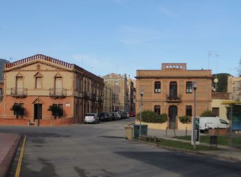 Road by buildings against sky in city