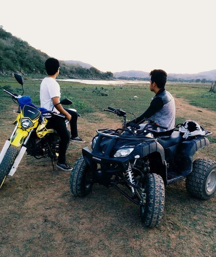 lifestyles, casual clothing, leisure activity, full length, sitting, grass, clear sky, childhood, field, transportation, land vehicle, boys, men, bicycle, mode of transport, person, togetherness