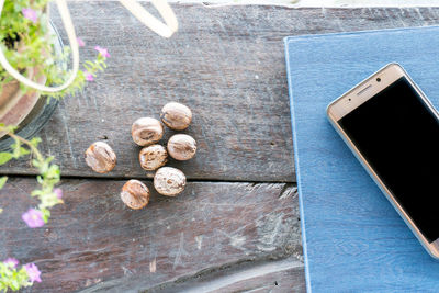 High angle view of smart phone with nuts on table