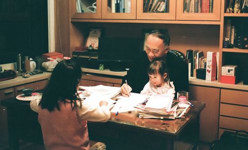 Father and daughter in book on table