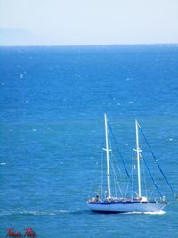 Boat sailing in sea against blue sky