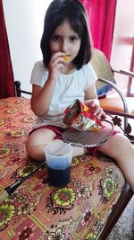 Portrait of woman sitting on table at home