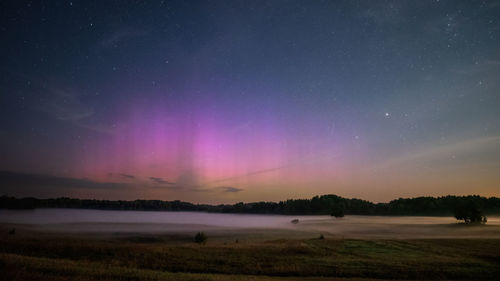 Scenic view of field against sky at night