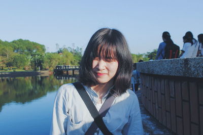 Beautiful woman standing by river against sky