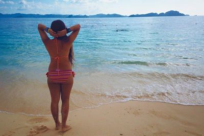 Rear view of woman standing on beach