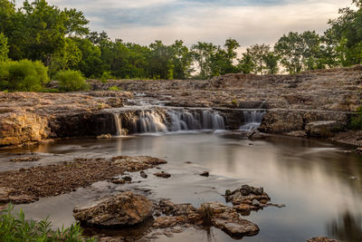 Scenic view of waterfall against sky