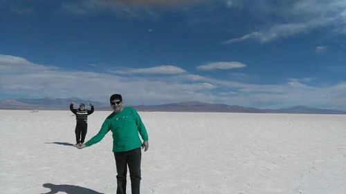 Full length of man standing on snowy field against sky