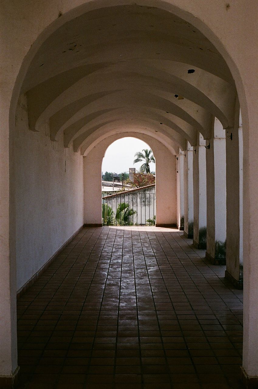 EMPTY CORRIDOR OF BUILDING WITH ARCHED WALLS