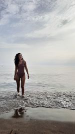 Full length of woman standing at beach