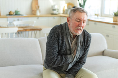 Young man sitting on sofa at home