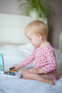 Portrait of cute baby boy playing with stuffed toy at home