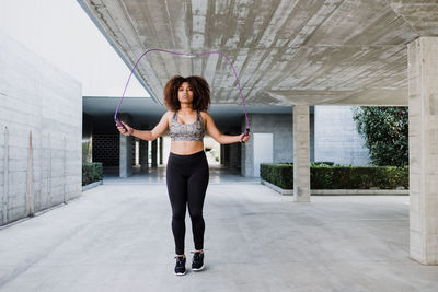 Curvy african american woman skipping rope in urban area