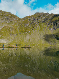 Scenic view of lake by mountains against sky