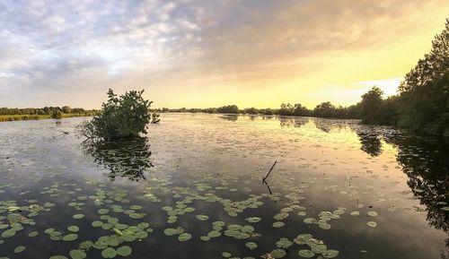 Scenic view of lake against sky at sunset