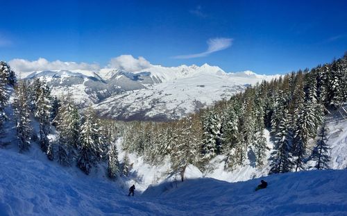 Scenic view of snowcapped mountains against blue sky