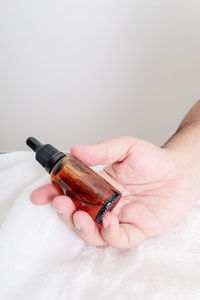 Close-up of hand holding light bulb against white background