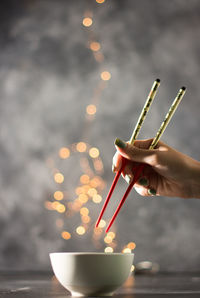 Hand with chopstick for holding sushi. asian cuisine.