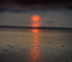 Surface level of beach against sky during sunset