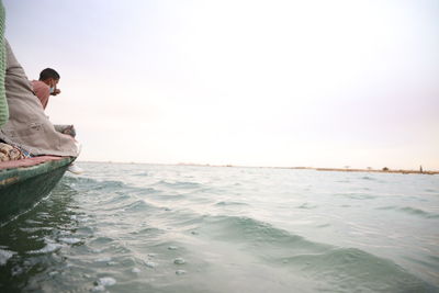 Man surfing in sea against clear sky