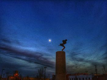 Low angle view of illuminated street light against blue sky