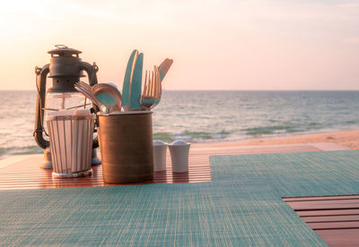 People on table by swimming pool against sea