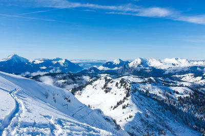 Scenic view of snow covered mountains against cloudy sky