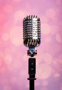 Close-up of microphone against pink background