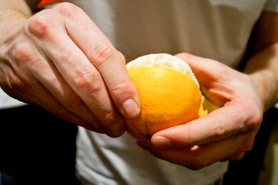 Midsection of man holding fruit