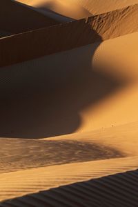 Scenic view of sand dunes against sky at sunset