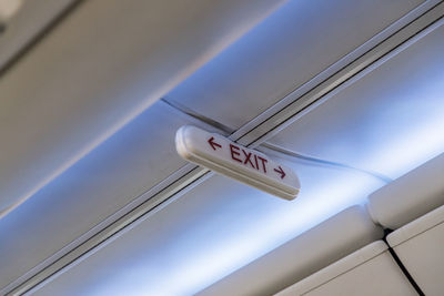 Low angle view of exit sign in airplane