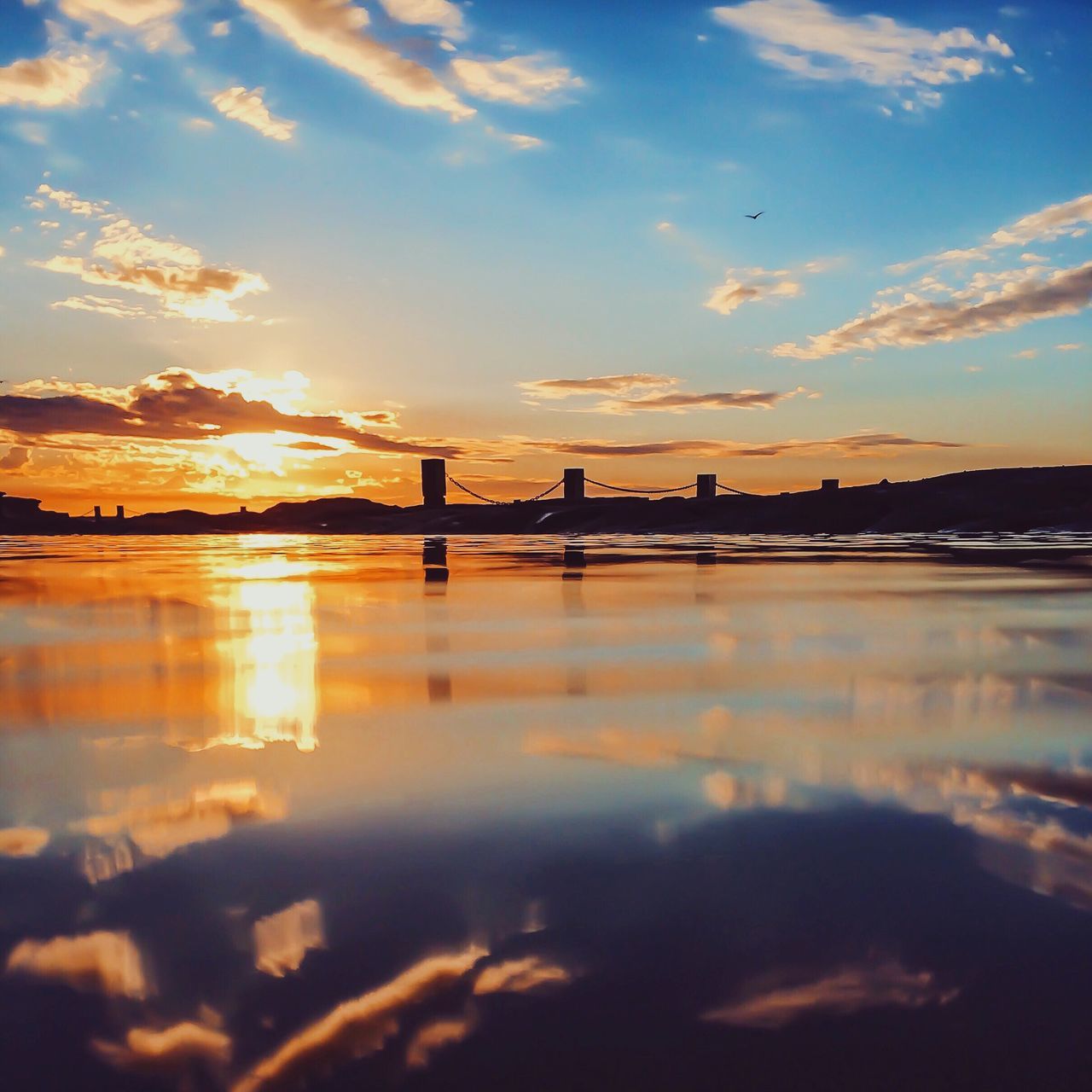 sunset, water, reflection, tranquil scene, scenics, tranquility, sun, idyllic, lake, sky, waterfront, cloud - sky, river, bridge - man made structure, calm, beauty in nature, cloud, nature, orange color, standing water, outdoors, sea, surface level, majestic, ocean, bridge, no people, remote