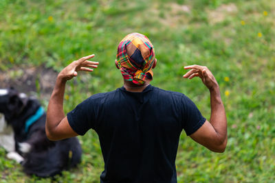 Midsection of man with arms raised standing on land