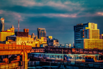 Illuminated buildings in city at sunset