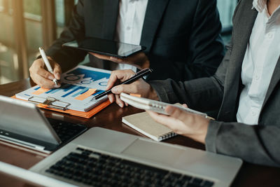 Midsection of man using laptop on table