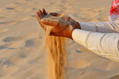 Low section of man standing on beach