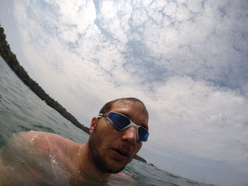 Fish-eye view of shirtless man swimming in sea