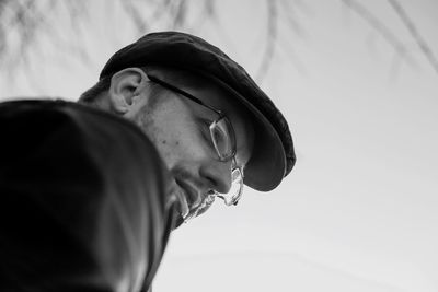 Low angle view of thoughtful man against clear sky