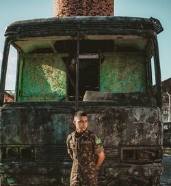 Soldier looking away while standing in front of truck