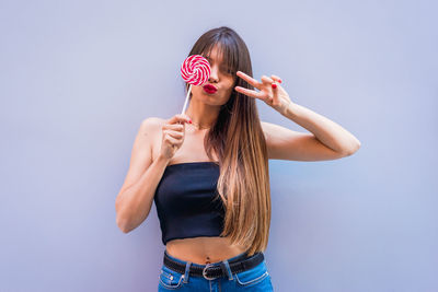 Full length of young woman standing against white background