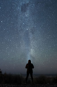 Full length of man standing on field against sky at night