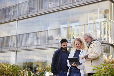 Men and woman with laptop looking in courtyard