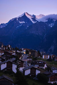 Aerial view of townscape by mountain against sky at night