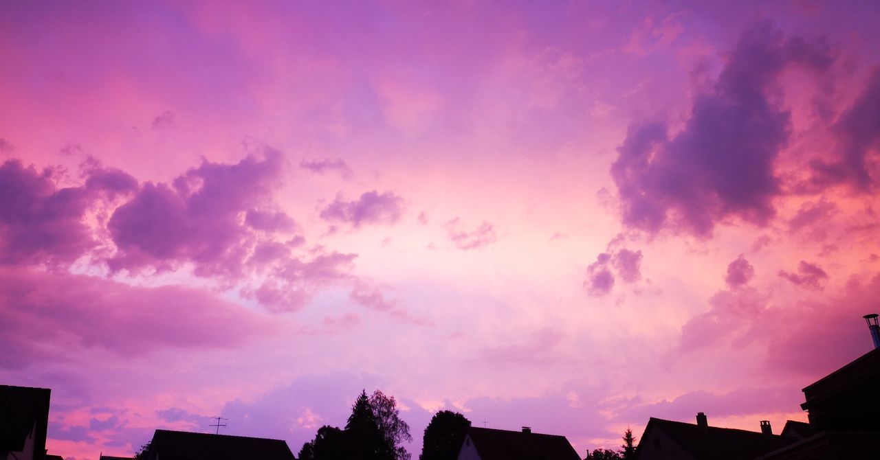 LOW ANGLE VIEW OF SILHOUETTE BUILDINGS AGAINST CLOUDY SKY