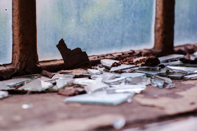 Broken glass on window sill at abandoned house