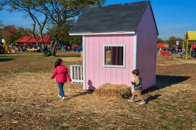 Kids running around and coloring in a chalk house at the farm fair on halloween