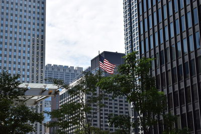 Low angle view of buildings in city against cloudy sky