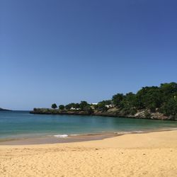 Scenic view of beach against clear blue sky