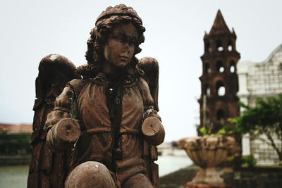 Statue of angel of a church against sky