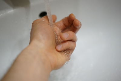 Close-up of baby hand on wet sand