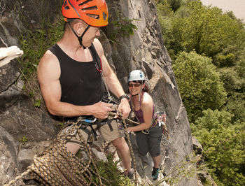 Couple climbing steep rock face in south wales